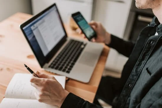 Pessoa mexendo no WhatsApp pelo celular e computador.